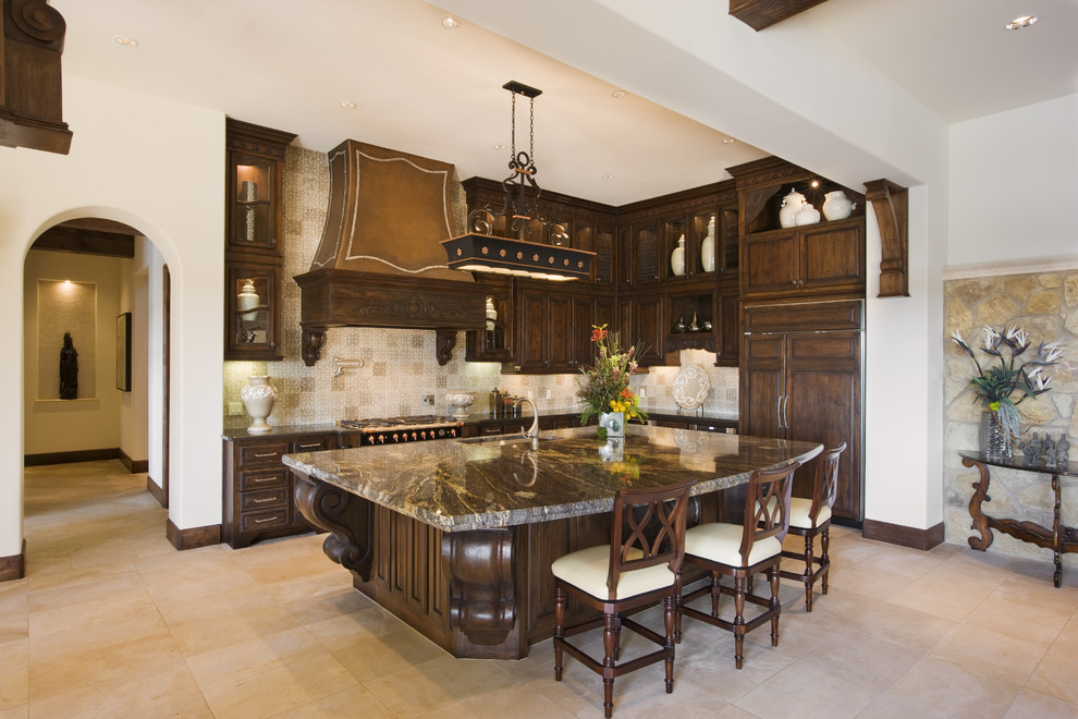 Example of a tuscan kitchen design in Austin with dark wood cabinets and paneled appliances