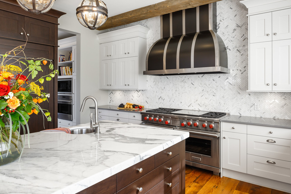 Design ideas for an expansive traditional u-shaped kitchen/diner in Ottawa with a belfast sink, shaker cabinets, dark wood cabinets, marble worktops, white splashback, mosaic tiled splashback, integrated appliances, medium hardwood flooring and an island.