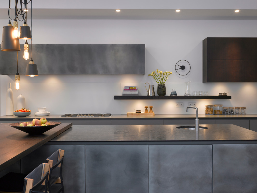 Large contemporary kitchen in London with a submerged sink, flat-panel cabinets, grey cabinets, composite countertops, stainless steel appliances and an island.