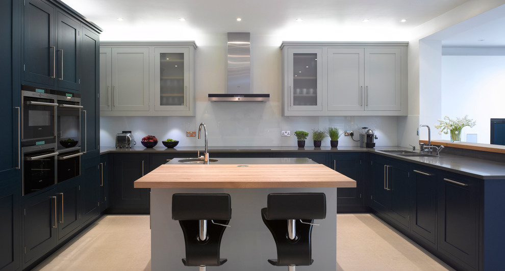 Offene, Große Moderne Küche mit Unterbauwaschbecken, flächenbündigen Schrankfronten, blauen Schränken und Mineralwerkstoff-Arbeitsplatte in London