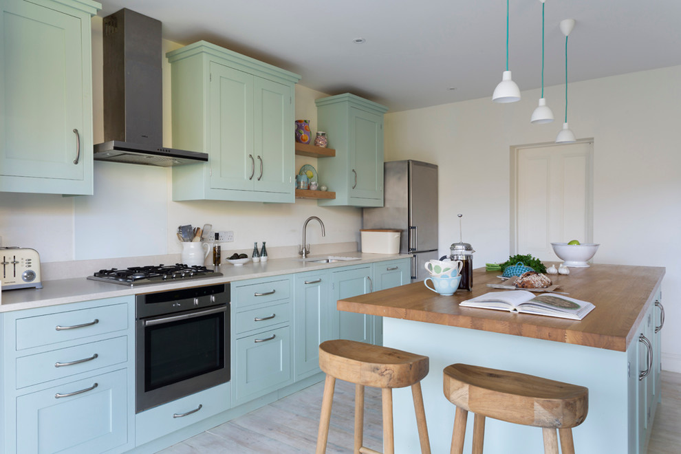 Inspiration for a large rural open plan kitchen in London with a submerged sink, recessed-panel cabinets, blue cabinets, wood worktops and an island.
