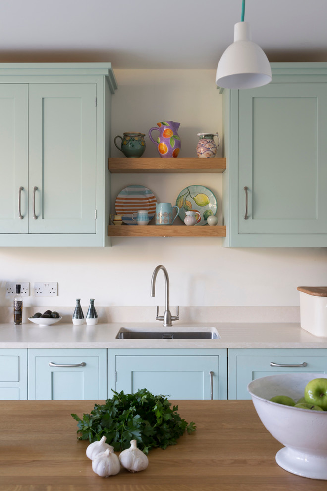 Exempel på ett stort lantligt kök med öppen planlösning, med en undermonterad diskho, luckor med infälld panel, blå skåp, träbänkskiva och en köksö