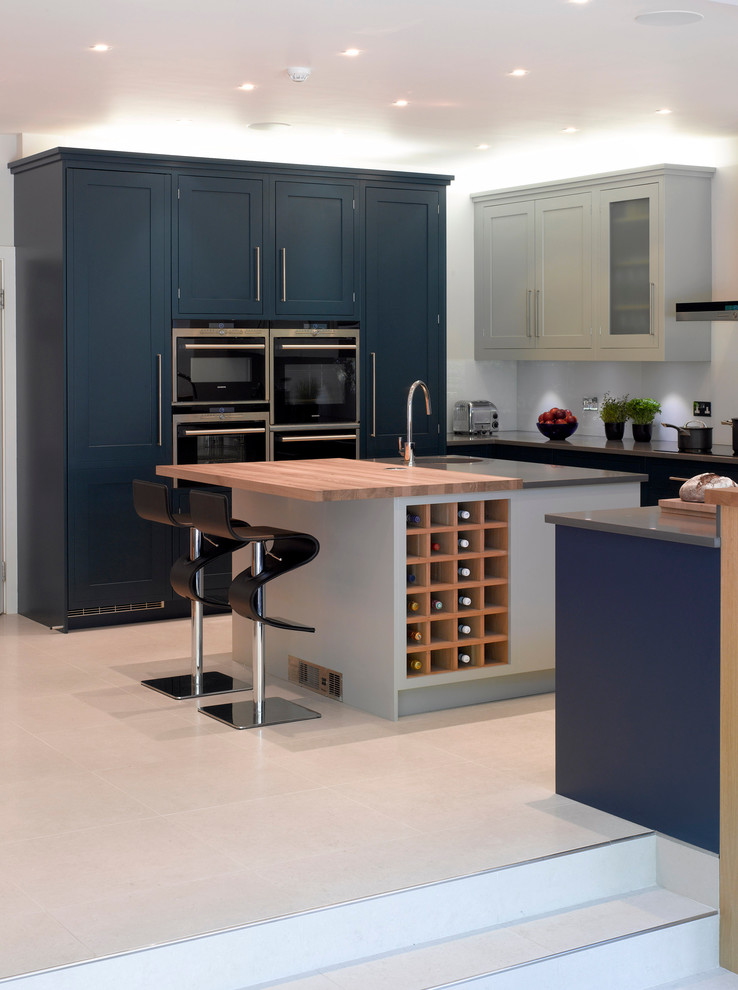 Foto de cocina actual grande abierta con armarios con paneles empotrados, puertas de armario azules y una isla