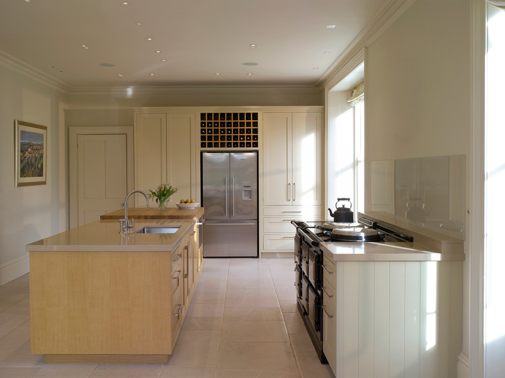 Large contemporary open plan kitchen in London with recessed-panel cabinets, light wood cabinets and an island.