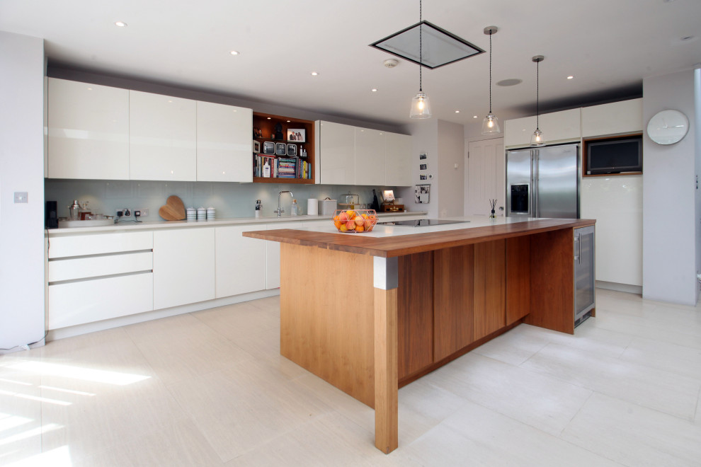 Inspiration for a medium sized contemporary l-shaped kitchen/diner in London with a built-in sink, flat-panel cabinets, white cabinets, quartz worktops, blue splashback, granite splashback, white appliances, ceramic flooring, an island, beige floors, white worktops and a drop ceiling.