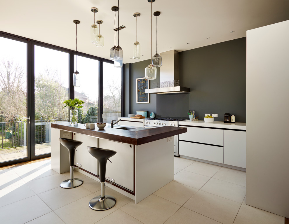 Große Moderne Wohnküche mit Unterbauwaschbecken, flächenbündigen Schrankfronten, weißen Schränken und Kücheninsel in London