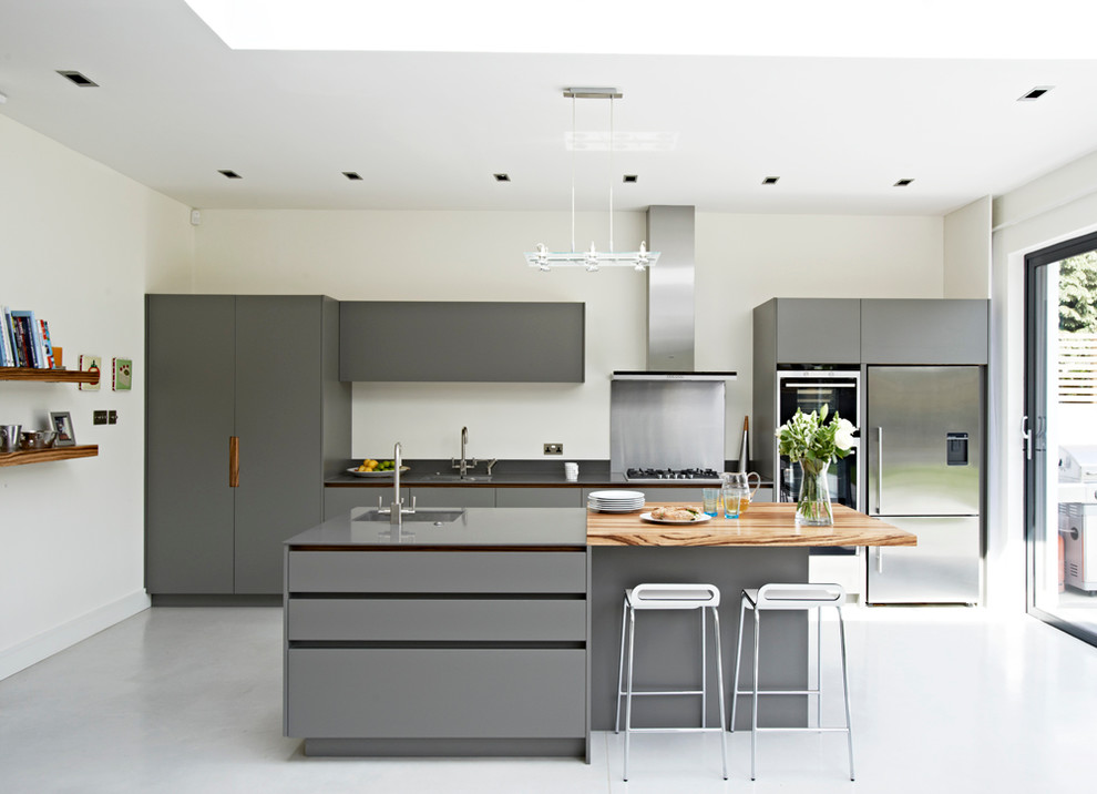 Large contemporary kitchen in London with flat-panel cabinets, grey cabinets, an island, a single-bowl sink and stainless steel appliances.