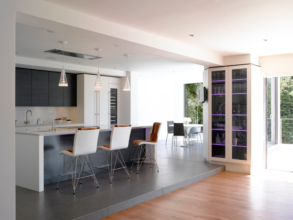 Open concept kitchen - large contemporary open concept kitchen idea in London with flat-panel cabinets and an island