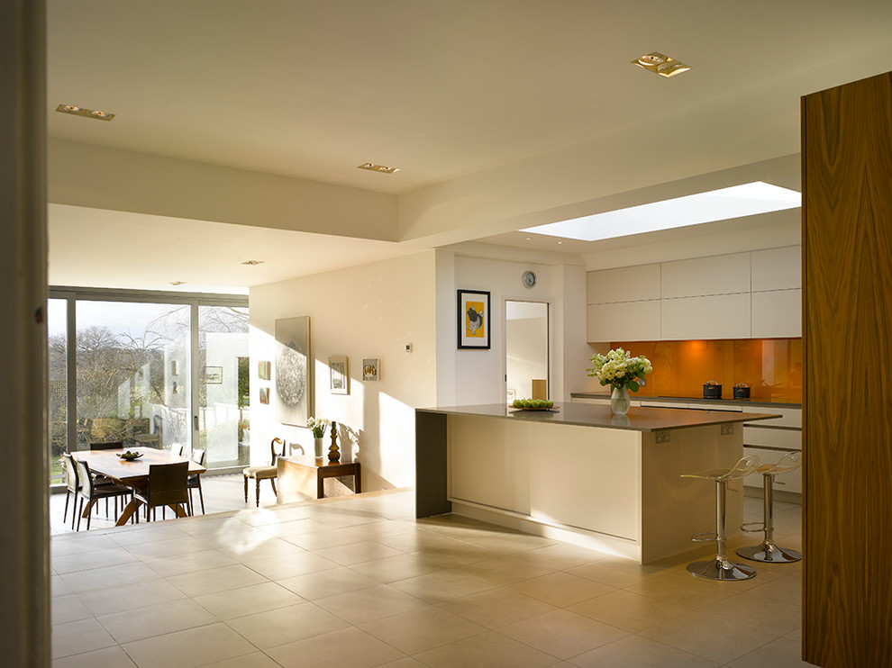 Exempel på ett stort modernt kök med öppen planlösning, med släta luckor, vita skåp, bänkskiva i koppar, orange stänkskydd, glaspanel som stänkskydd och en köksö