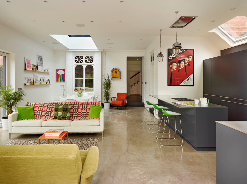 Example of a large trendy open concept kitchen design in London with an undermount sink, flat-panel cabinets, gray cabinets, stainless steel countertops, white backsplash, ceramic backsplash, stainless steel appliances and an island