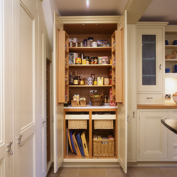 Example of a large trendy kitchen pantry design in London with recessed-panel cabinets and beige cabinets
