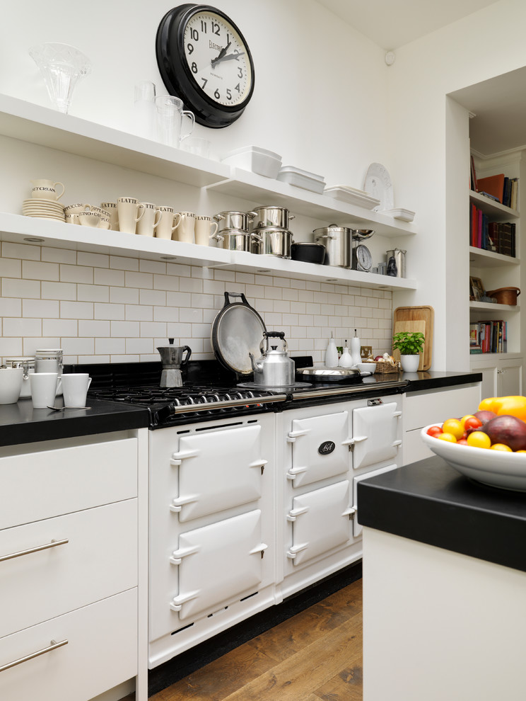 Große Moderne Küche mit flächenbündigen Schrankfronten, weißen Schränken, Mineralwerkstoff-Arbeitsplatte und Unterbauwaschbecken in London