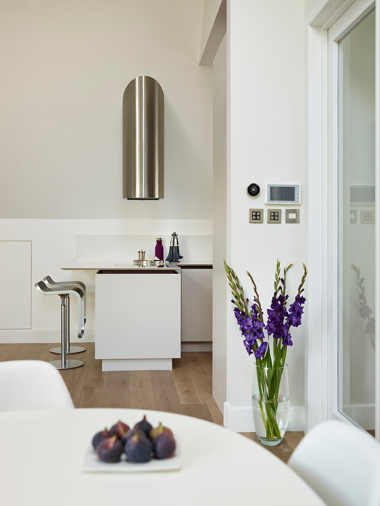 Idee per una piccola cucina ad ambiente unico design con lavello sottopiano, ante lisce, ante bianche, top in superficie solida e elettrodomestici in acciaio inossidabile