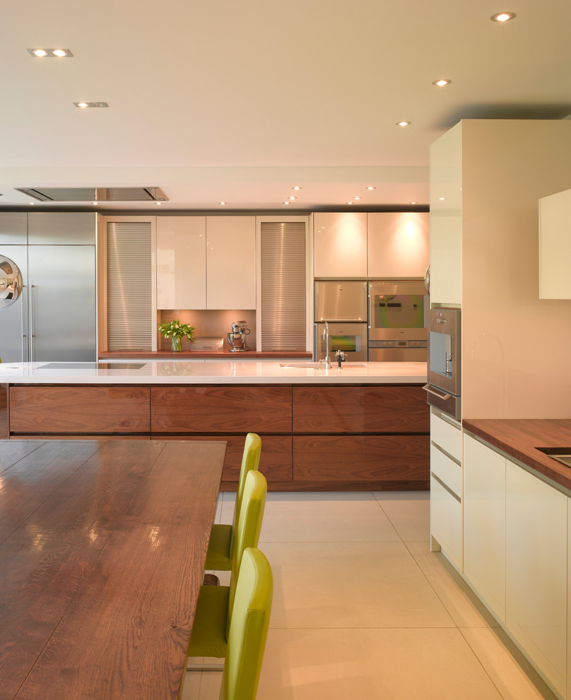 Inspiration for a large contemporary open plan kitchen in London with flat-panel cabinets, medium wood cabinets, wood worktops and an island.