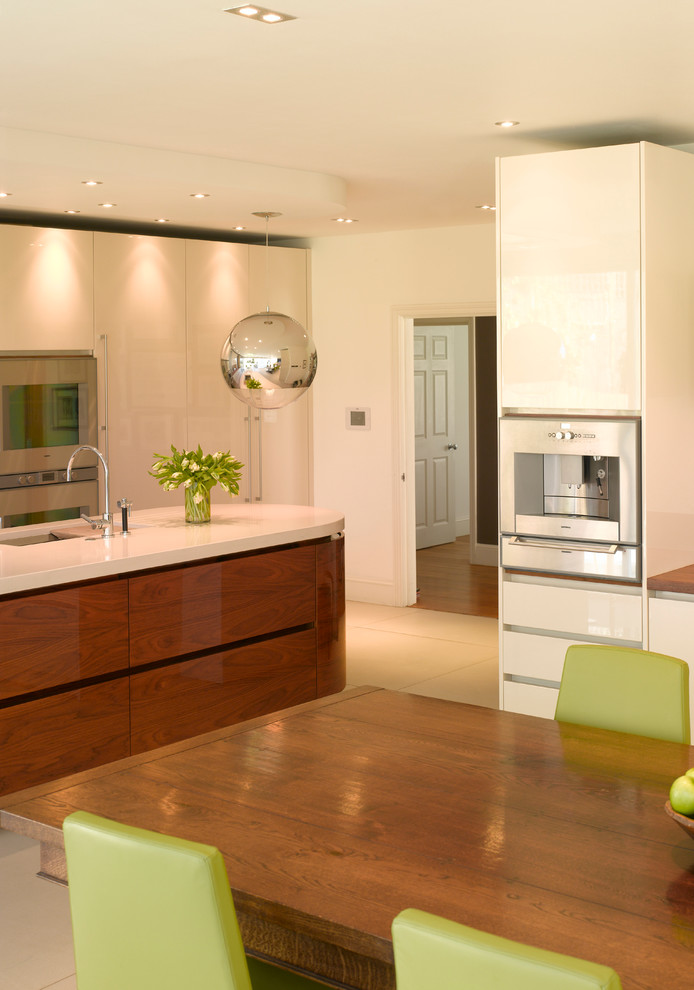 Example of a large trendy open concept kitchen design in London with flat-panel cabinets, medium tone wood cabinets, wood countertops and an island