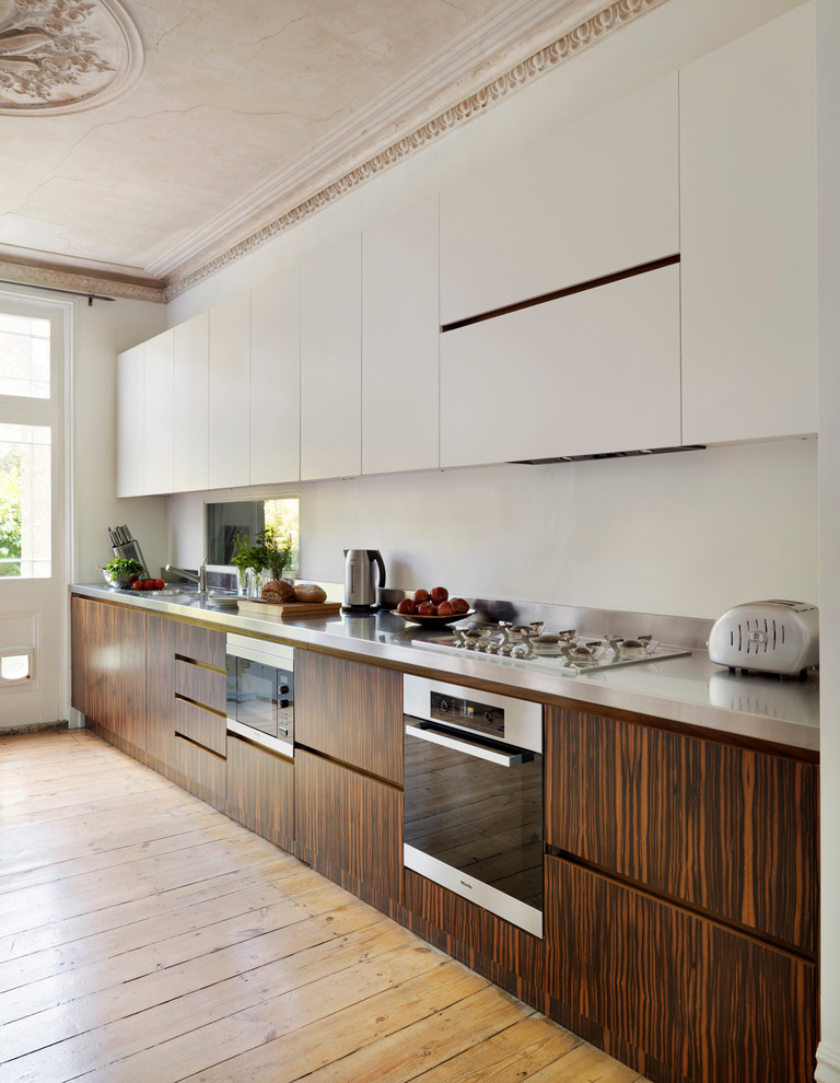 Large trendy open concept kitchen photo in London with flat-panel cabinets, dark wood cabinets and wood countertops