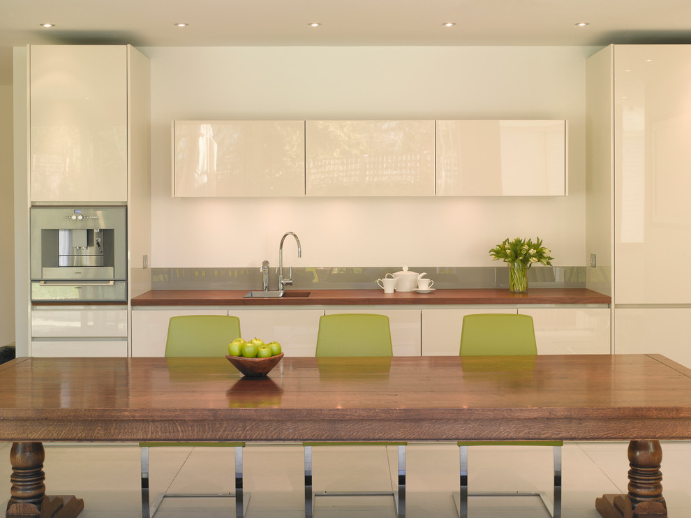 Offene, Große Moderne Küche mit flächenbündigen Schrankfronten, hellbraunen Holzschränken, Arbeitsplatte aus Holz und Kücheninsel in London