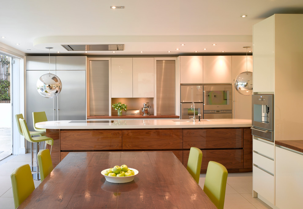 This is an example of a large contemporary open plan kitchen in London with flat-panel cabinets, medium wood cabinets, wood worktops and an island.