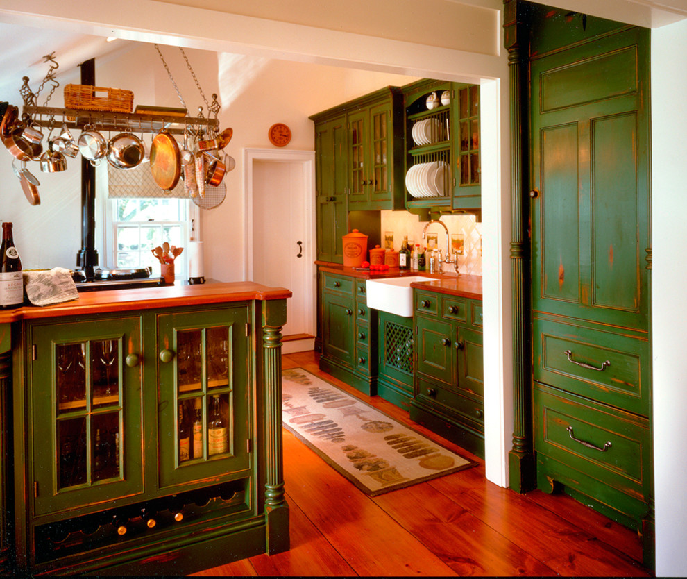 Cette photo montre une cuisine américaine nature en bois vieilli de taille moyenne avec un évier de ferme, un placard à porte affleurante et un plan de travail en bois.