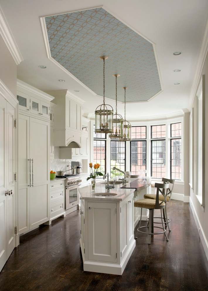 Enclosed kitchen - mid-sized traditional galley dark wood floor enclosed kitchen idea in Boston with an undermount sink, shaker cabinets, white cabinets, white backsplash, paneled appliances, an island, marble countertops and subway tile backsplash