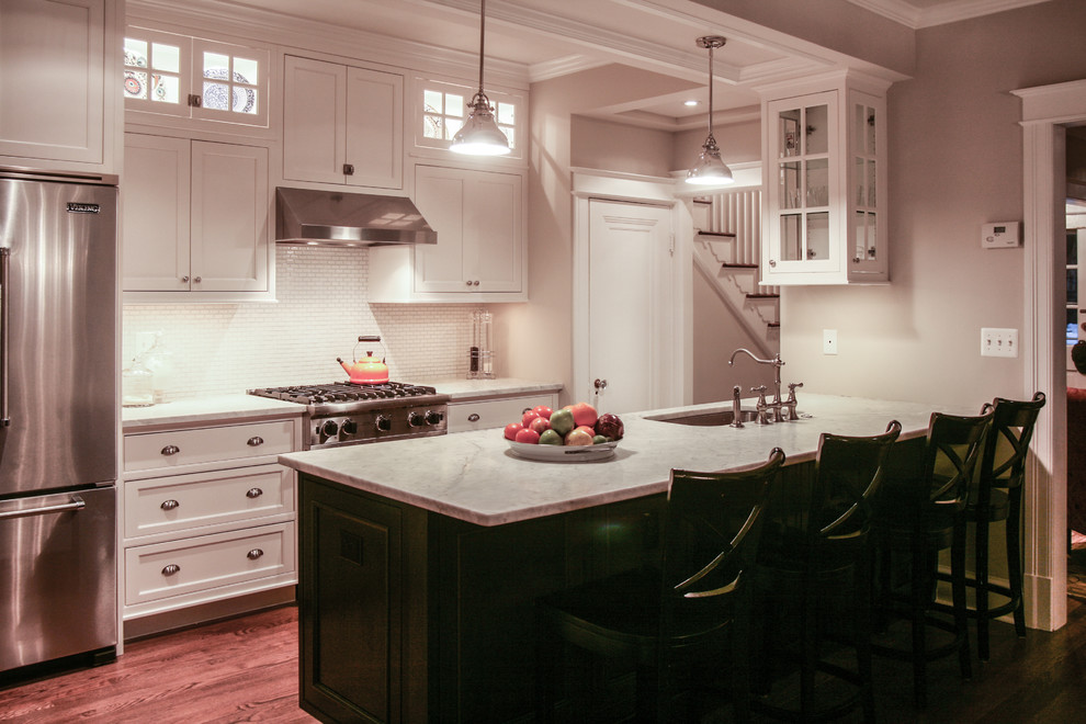 Foto på ett litet vintage kök, med en undermonterad diskho, luckor med profilerade fronter, vita skåp, marmorbänkskiva, stänkskydd i mosaik, rostfria vitvaror, mellanmörkt trägolv, vitt stänkskydd och en köksö