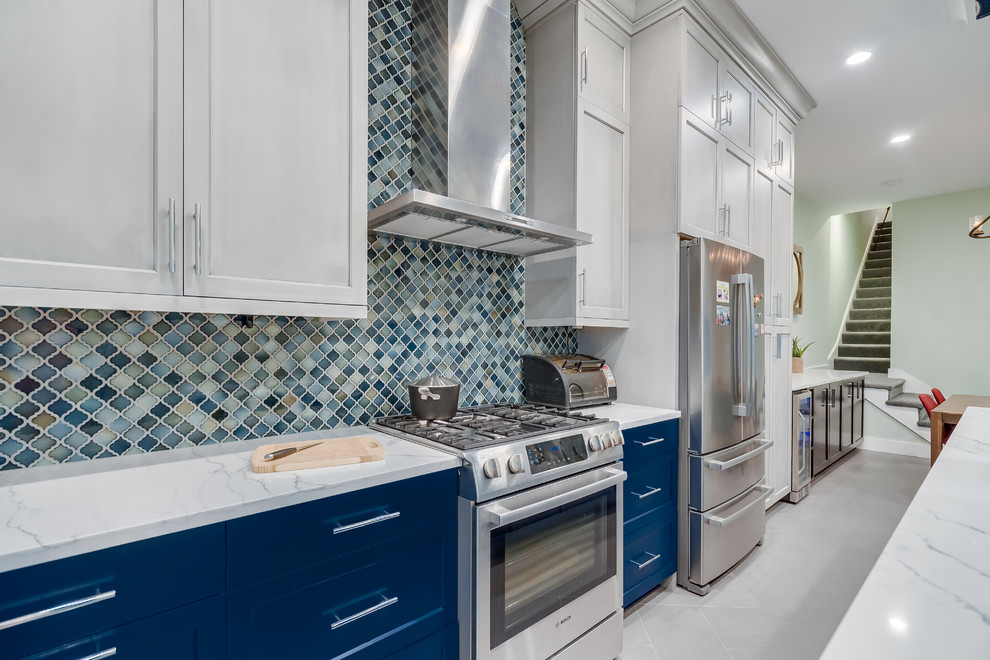 Example of a mid-sized trendy l-shaped porcelain tile and gray floor eat-in kitchen design in DC Metro with an undermount sink, blue cabinets, quartz countertops, multicolored backsplash, ceramic backsplash, stainless steel appliances, an island, white countertops and shaker cabinets