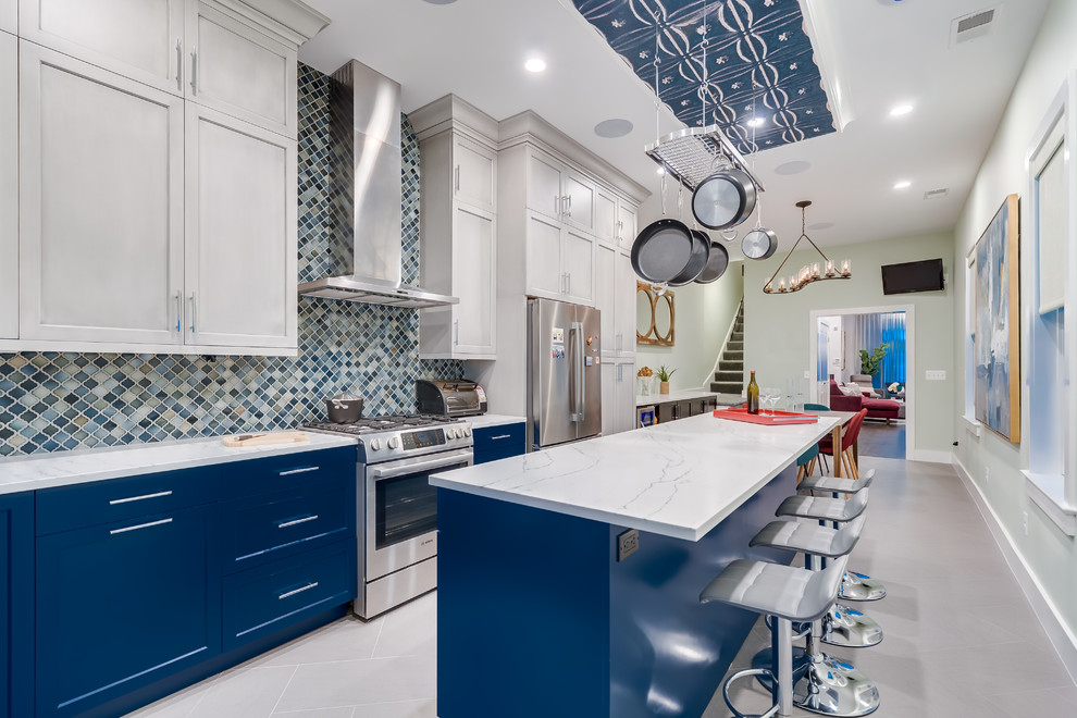 Mid-sized trendy l-shaped porcelain tile and gray floor eat-in kitchen photo in DC Metro with an undermount sink, blue cabinets, quartz countertops, multicolored backsplash, ceramic backsplash, stainless steel appliances, an island, white countertops and shaker cabinets