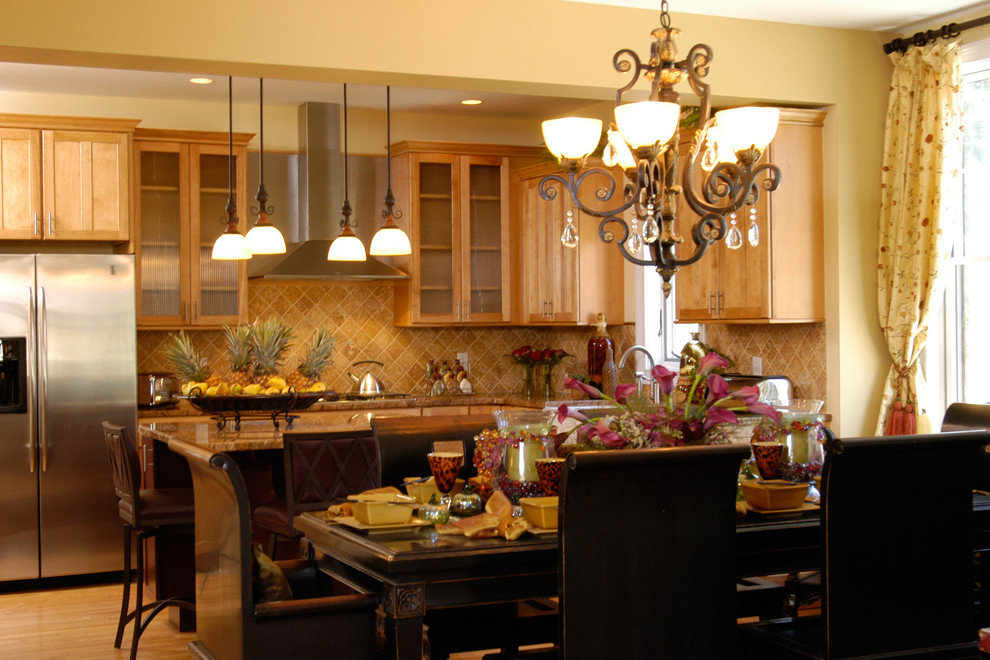 Inredning av ett medelhavsstil mellanstort kök, med en rustik diskho, luckor med infälld panel, skåp i mellenmörkt trä, granitbänkskiva, beige stänkskydd, stänkskydd i travertin, rostfria vitvaror, mellanmörkt trägolv, en köksö och brunt golv