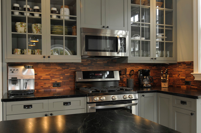Inspiration for a transitional u-shaped kitchen remodel in New York with an island, green cabinets, brown backsplash and soapstone countertops