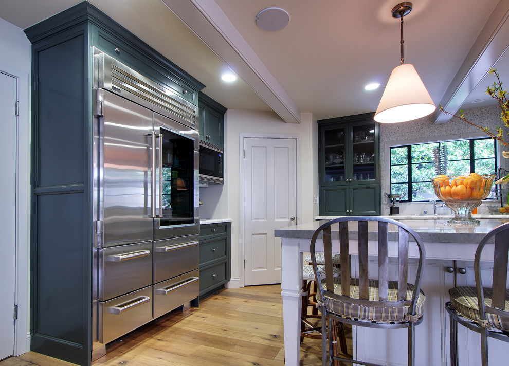 Enclosed kitchen - large traditional l-shaped light wood floor enclosed kitchen idea in Los Angeles with green cabinets, mosaic tile backsplash, stainless steel appliances, an island, recessed-panel cabinets, granite countertops and multicolored backsplash