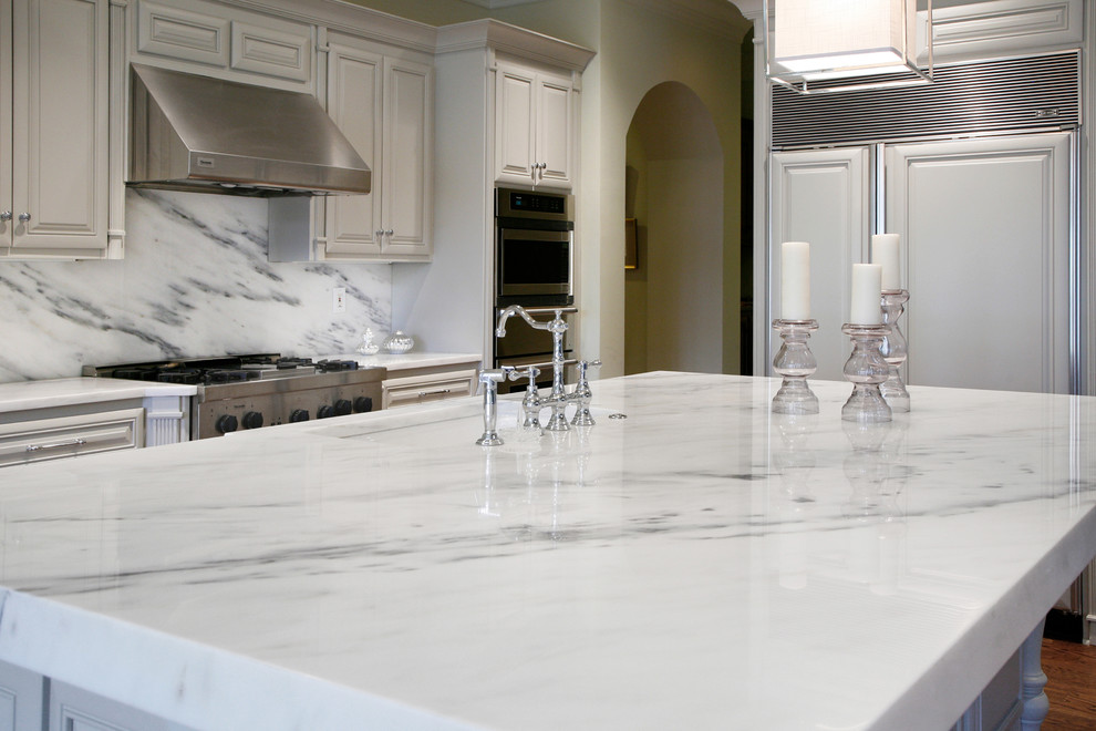 Example of a classic kitchen design in Atlanta with marble countertops, stone slab backsplash and an island