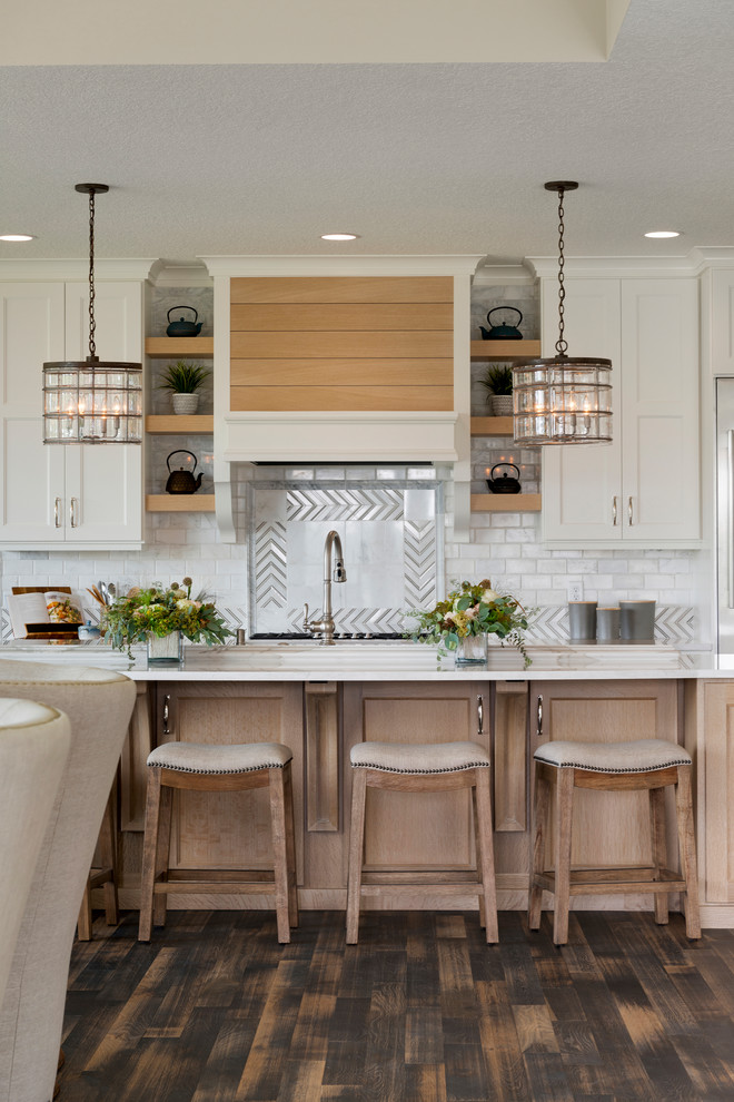 Inspiration for a classic kitchen in Minneapolis with recessed-panel cabinets, white cabinets, metallic splashback, metal splashback, an island, brown floors and white worktops.