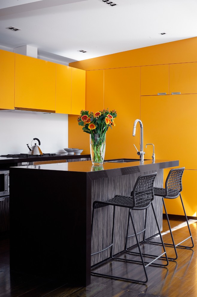 На фото: кухня в стиле модернизм с плоскими фасадами и оранжевыми фасадами с