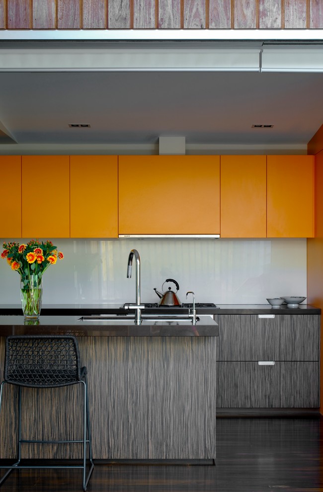 Modern kitchen in Sydney with flat-panel cabinets, orange cabinets and grey splashback.