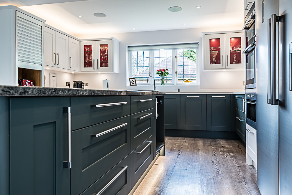 Cette image montre une grande cuisine minimaliste avec un placard à porte shaker, des portes de placard bleues et un plan de travail multicolore.