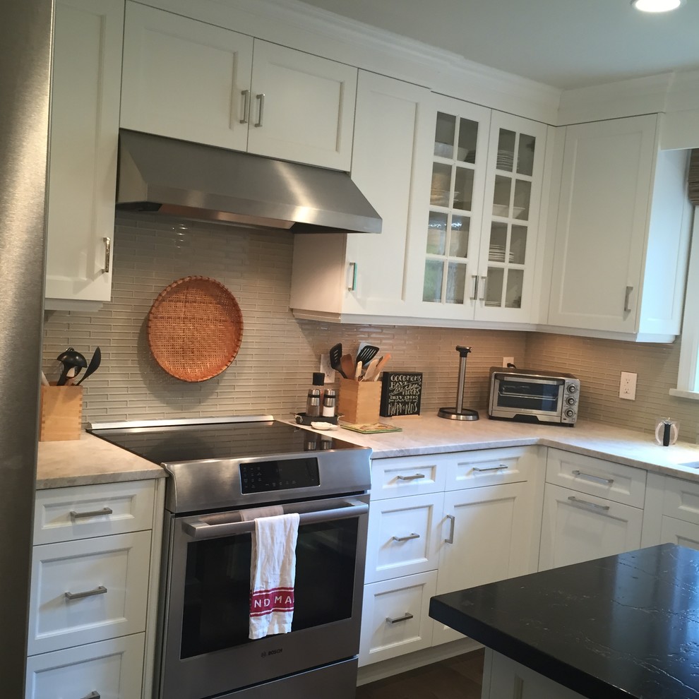 Exempel på ett mellanstort klassiskt kök, med en undermonterad diskho, luckor med infälld panel, vita skåp, bänkskiva i kvartsit, beige stänkskydd, stänkskydd i glaskakel, rostfria vitvaror, mellanmörkt trägolv och en köksö