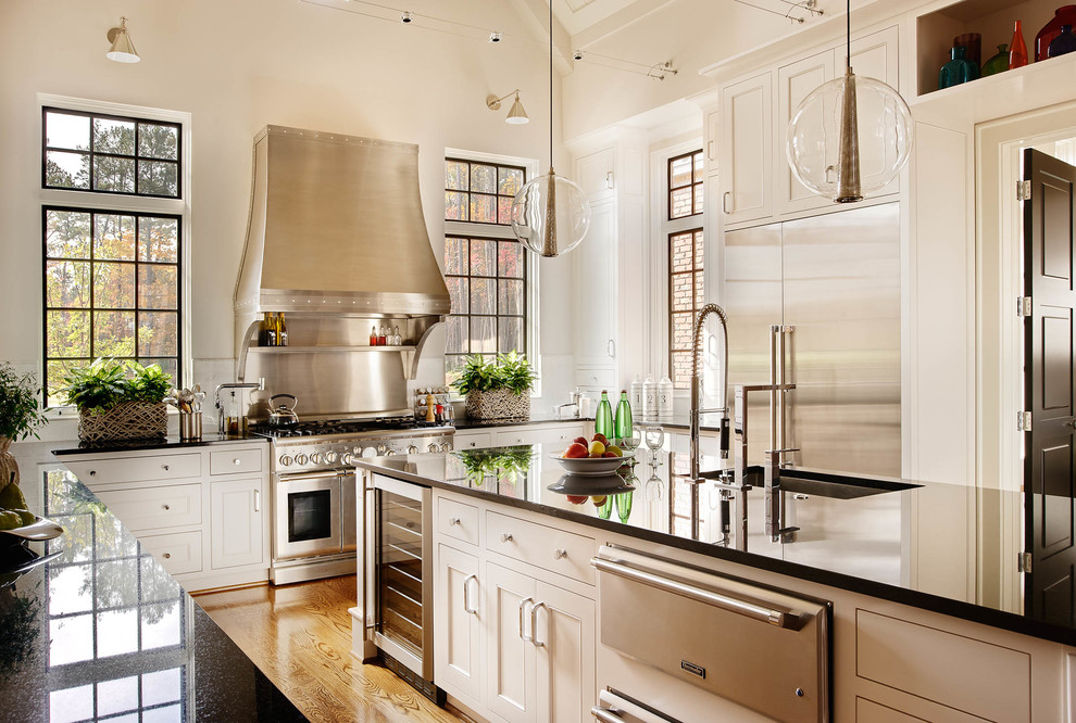 This is an example of a traditional u-shaped kitchen/diner in Raleigh with shaker cabinets, white cabinets and stainless steel appliances.