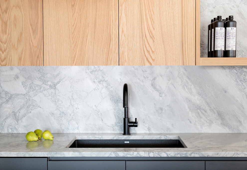 Foto di una cucina stile marinaro con lavello da incasso, ante a filo, ante in legno chiaro, top in marmo, paraspruzzi grigio, paraspruzzi in marmo e top grigio
