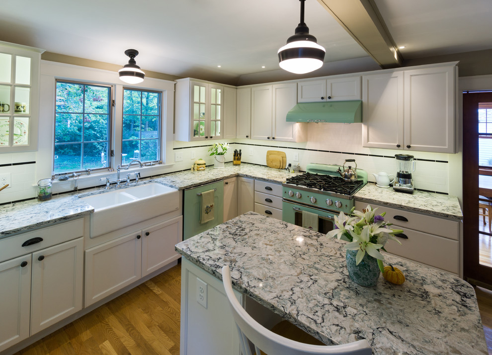 Inspiration for a mid-sized mid-century modern u-shaped medium tone wood floor kitchen remodel in Providence with a farmhouse sink, recessed-panel cabinets, white cabinets, quartz countertops, white backsplash, cement tile backsplash, colored appliances and an island