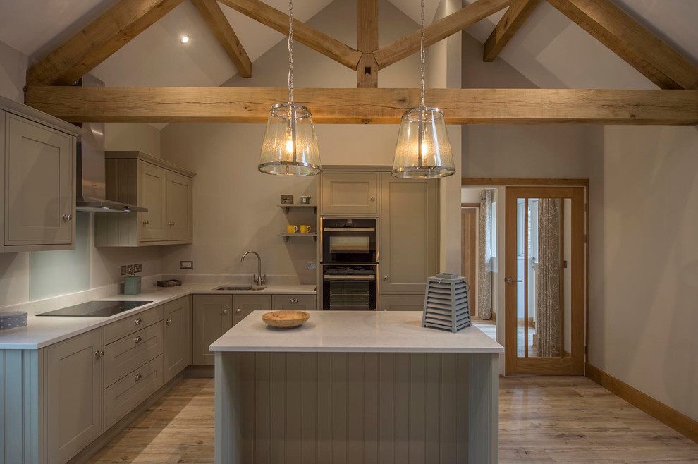 Photo of a farmhouse l-shaped open plan kitchen in Other with a built-in sink, shaker cabinets, grey cabinets, marble worktops, grey splashback, stone tiled splashback, stainless steel appliances, medium hardwood flooring and an island.