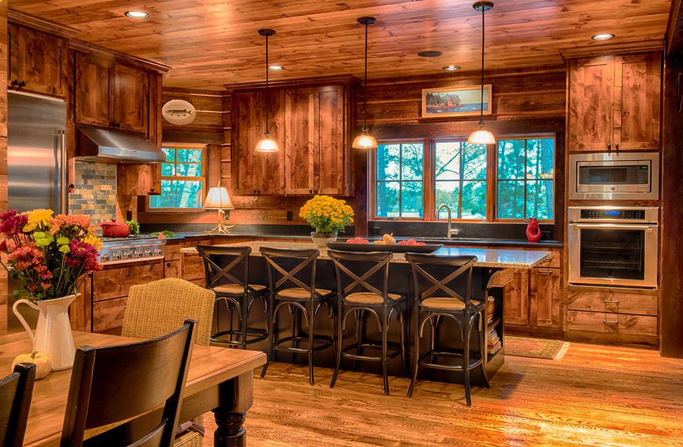 Foto på ett rustikt kök och matrum, med en undermonterad diskho, skåp i shakerstil, skåp i mellenmörkt trä, granitbänkskiva, flerfärgad stänkskydd, stänkskydd i stenkakel, rostfria vitvaror, mellanmörkt trägolv och en köksö