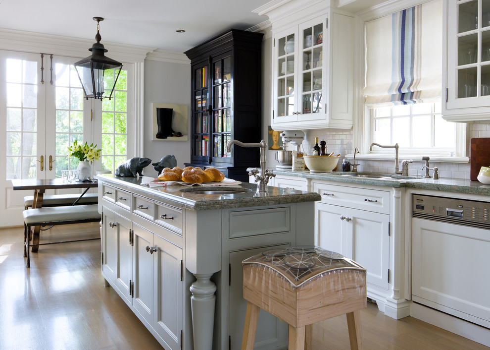 Example of a classic eat-in kitchen design in Toronto with an undermount sink, recessed-panel cabinets, white cabinets, white backsplash, subway tile backsplash and paneled appliances