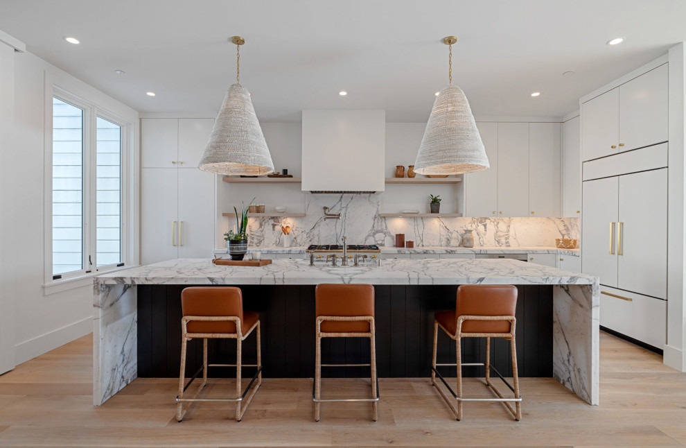 Example of a trendy medium tone wood floor and brown floor kitchen design in San Francisco with an undermount sink, flat-panel cabinets, white cabinets, marble countertops, gray backsplash, marble backsplash, paneled appliances, an island and gray countertops