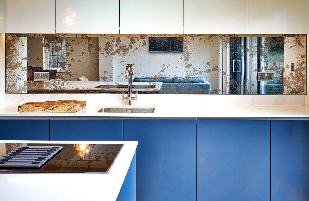 Foto di una cucina design di medie dimensioni con lavello da incasso, ante lisce, ante blu, top in quarzite, paraspruzzi marrone, paraspruzzi con lastra di vetro, elettrodomestici neri, parquet scuro, pavimento marrone e top beige