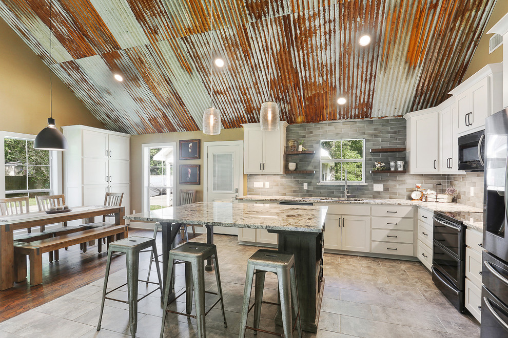 Example of a large eclectic l-shaped porcelain tile and gray floor eat-in kitchen design in New Orleans with an undermount sink, recessed-panel cabinets, white cabinets, granite countertops, gray backsplash, ceramic backsplash, black appliances, an island and multicolored countertops