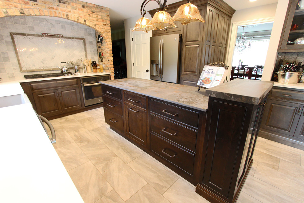 Inspiration for a large transitional l-shaped kitchen pantry remodel in Cleveland with a farmhouse sink, raised-panel cabinets, green cabinets, quartz countertops, white backsplash, stone tile backsplash, stainless steel appliances, an island and white countertops