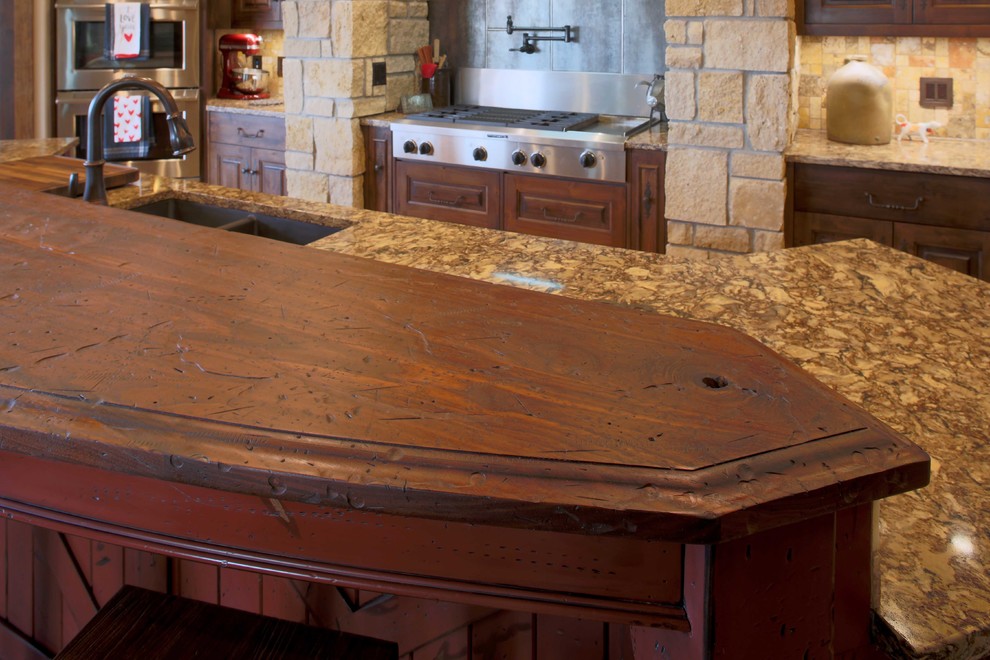 Inredning av ett rustikt stort linjärt kök med öppen planlösning, med en undermonterad diskho, luckor med upphöjd panel, skåp i mörkt trä, bänkskiva i kvarts, beige stänkskydd, stänkskydd i porslinskakel, rostfria vitvaror, mellanmörkt trägolv och en köksö