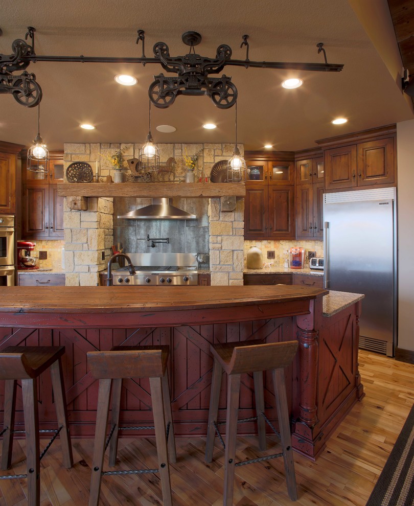 Inspiration for a large rustic single-wall open plan kitchen in Kansas City with a submerged sink, raised-panel cabinets, dark wood cabinets, engineered stone countertops, beige splashback, porcelain splashback, stainless steel appliances, medium hardwood flooring and an island.