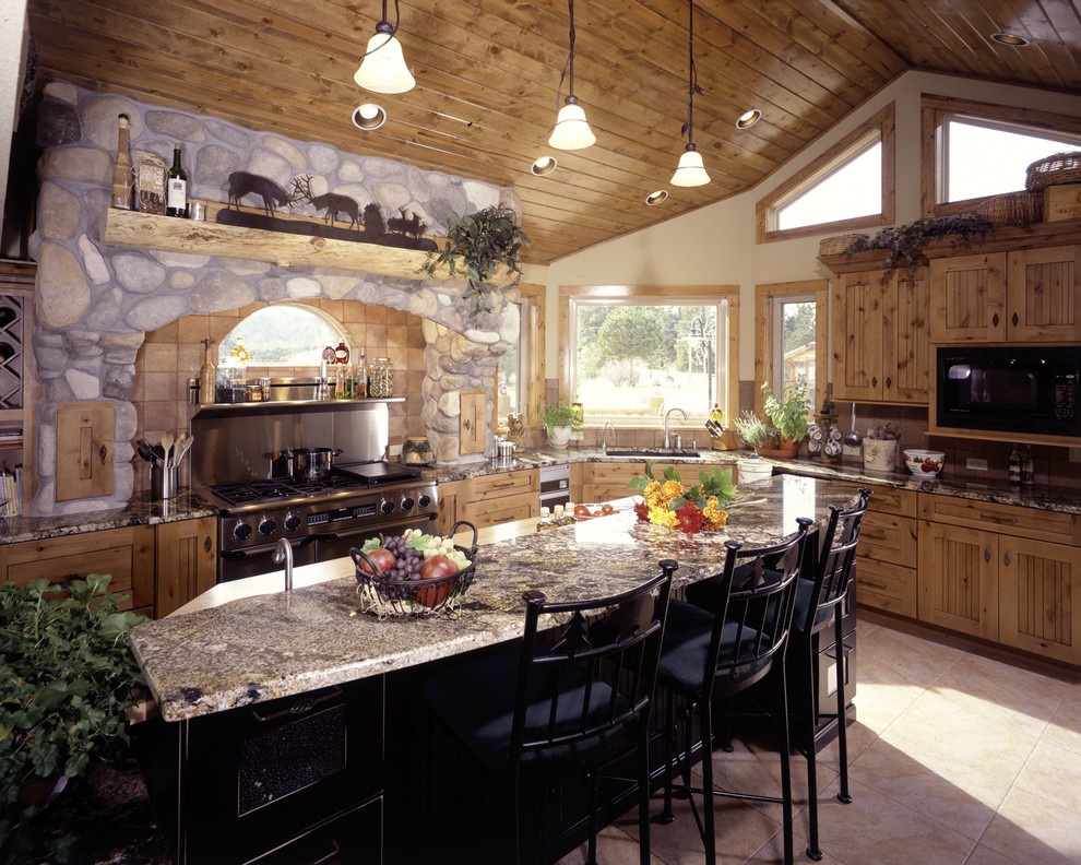 Exemple d'une cuisine américaine chic en bois vieilli de taille moyenne avec un plan de travail en granite, un électroménager en acier inoxydable et îlot.