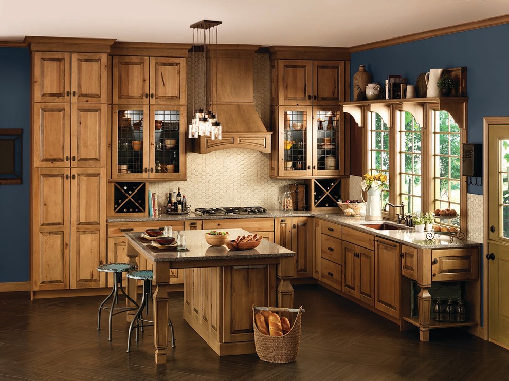 Diseño de cocinas en L rural con armarios con paneles con relieve, puertas de armario de madera clara, encimera de granito y una isla